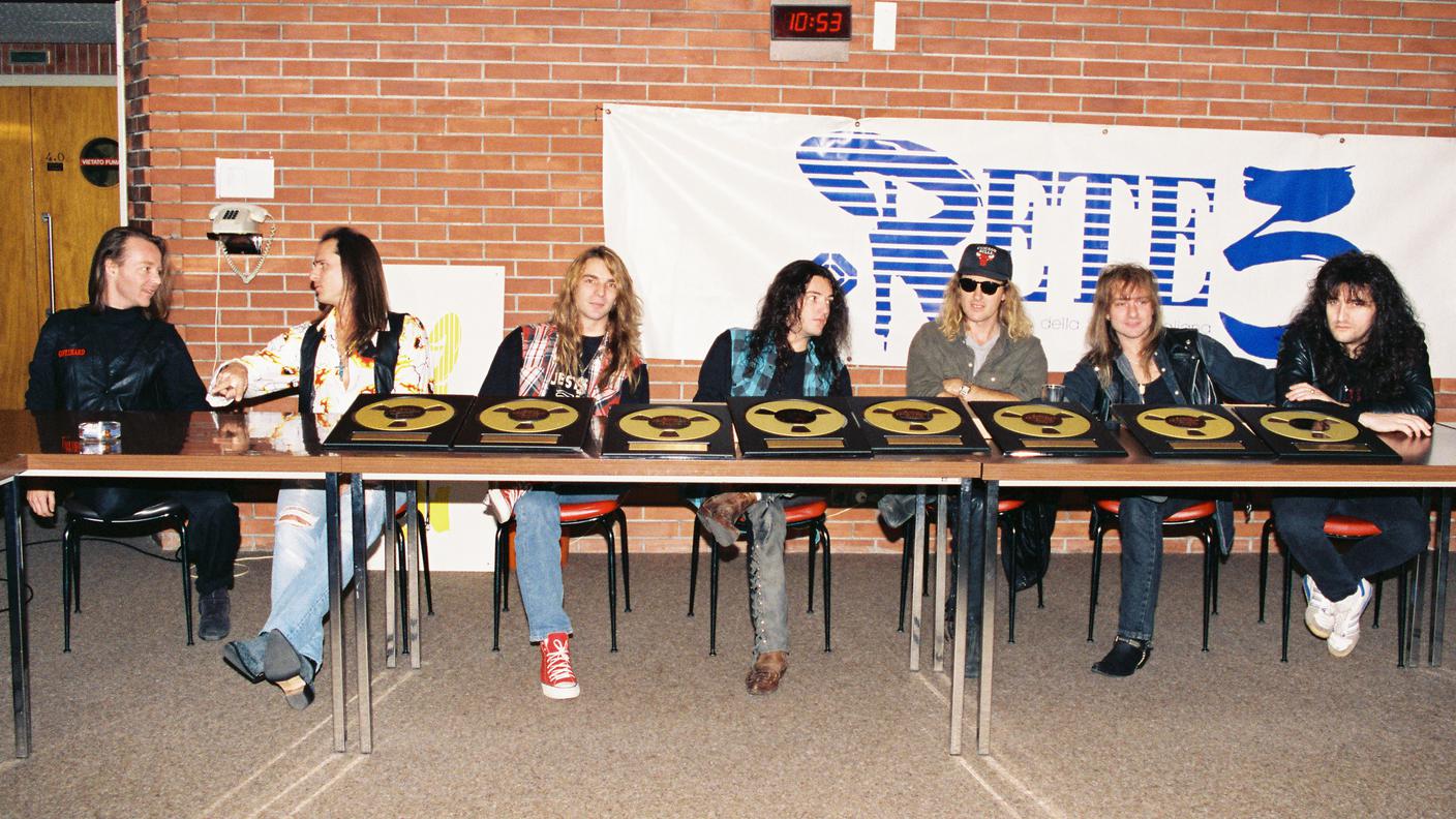 da sinistra: Gian Luca Verga (voce della prima Rete 3) fa gli onori di casa con Steve Lee (voce), Marc Lynn (basso), Hena Habegger (batteria), Chris von Rohr (produttore), Leo Leoni (chitarra) e Neil Otupacca (tastiere)