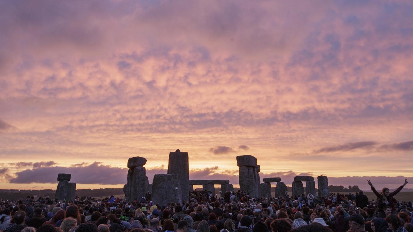 Il sole sorge mentre migliaia di persone si riuniscono presso l'antico cerchio di pietre di Stonehenge (Salisbury, in Inghilterra) per celebrare il solstizio d'estate, il giorno più lungo dell'anno