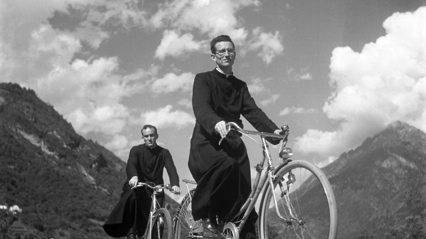 Due sacerdoti evangelici in bicicletta, fotografati a Roveredo, nel Cantone Ticino, in Svizzera, nell'agosto del 1951