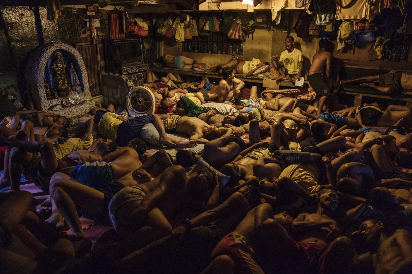 Alcuni detenuti dormono accanto a una piccola grotta dedicata alla Madonna nel carcere di Manila, nelle Filippine, il 31 ottobre 2018. Nelle Filippine, gli uomini in attesa di giudizio trascorrono mesi, a volte anni, in celle sovraffollate in attesa di un'incriminazione, di una sentenza o del processo.