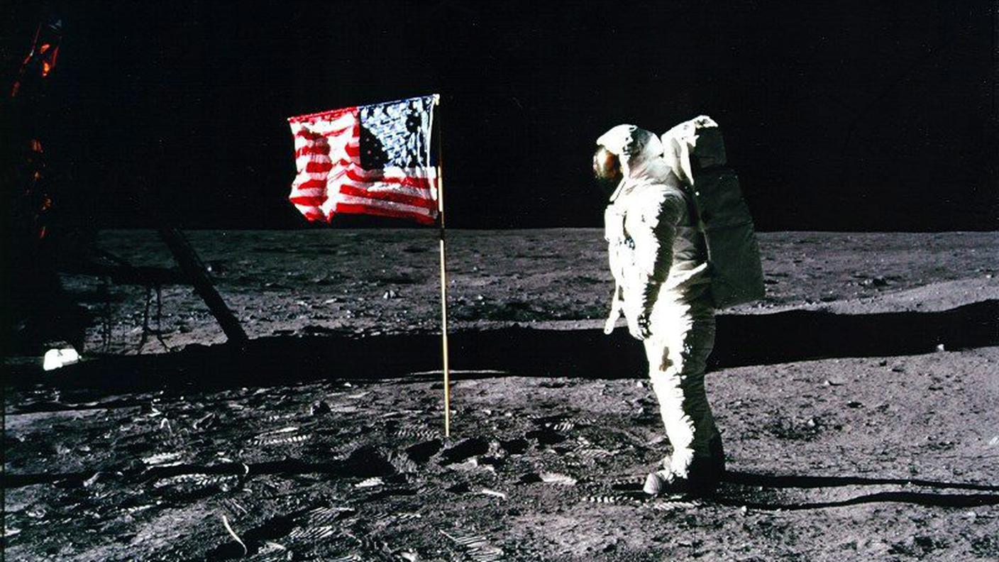 L'astronauta Edwin "Buzz" Aldrin osserva la bandiera americana sulla superficie lunare