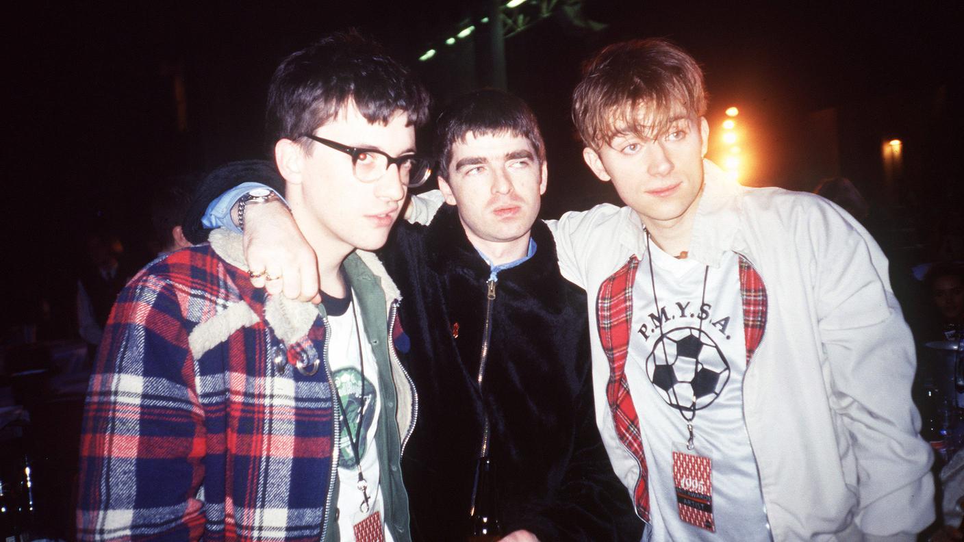 Noel Gallagher (Oasis) tra Graham Coxon e Damon Albarn (Blur)
