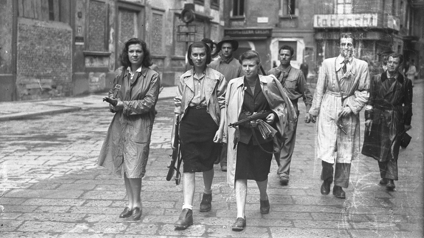 Tre ragazze aggregate ai gruppi partigiani, in Piazza Brera mentre perlustrano la città insieme ai "gappisti". Milano, 26 aprile 1945
