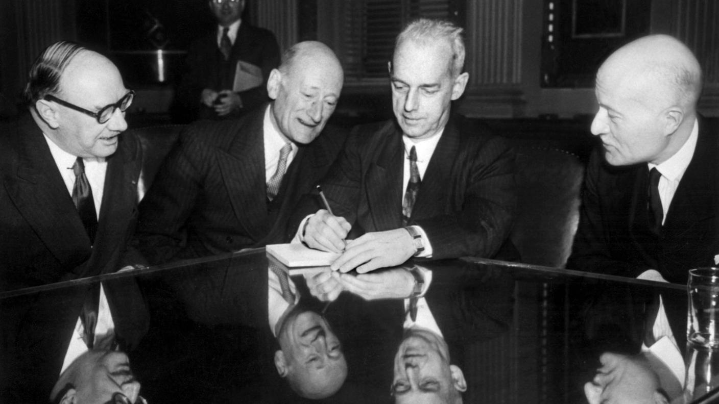 F.W. McCombe per la Gran Bretagna, Walter Stucki, delegato del Consiglio federale svizzero, Randolph Paul per gli Stati Uniti e François Chargueraud per la Francia (da sinistra) conversano il 19 marzo 1946 a Washington durante i negoziati tra gli Alleati occidentali e la Svizzera sul tema dell’oro nazista e dei beni tedeschi presenti in Svizzera.