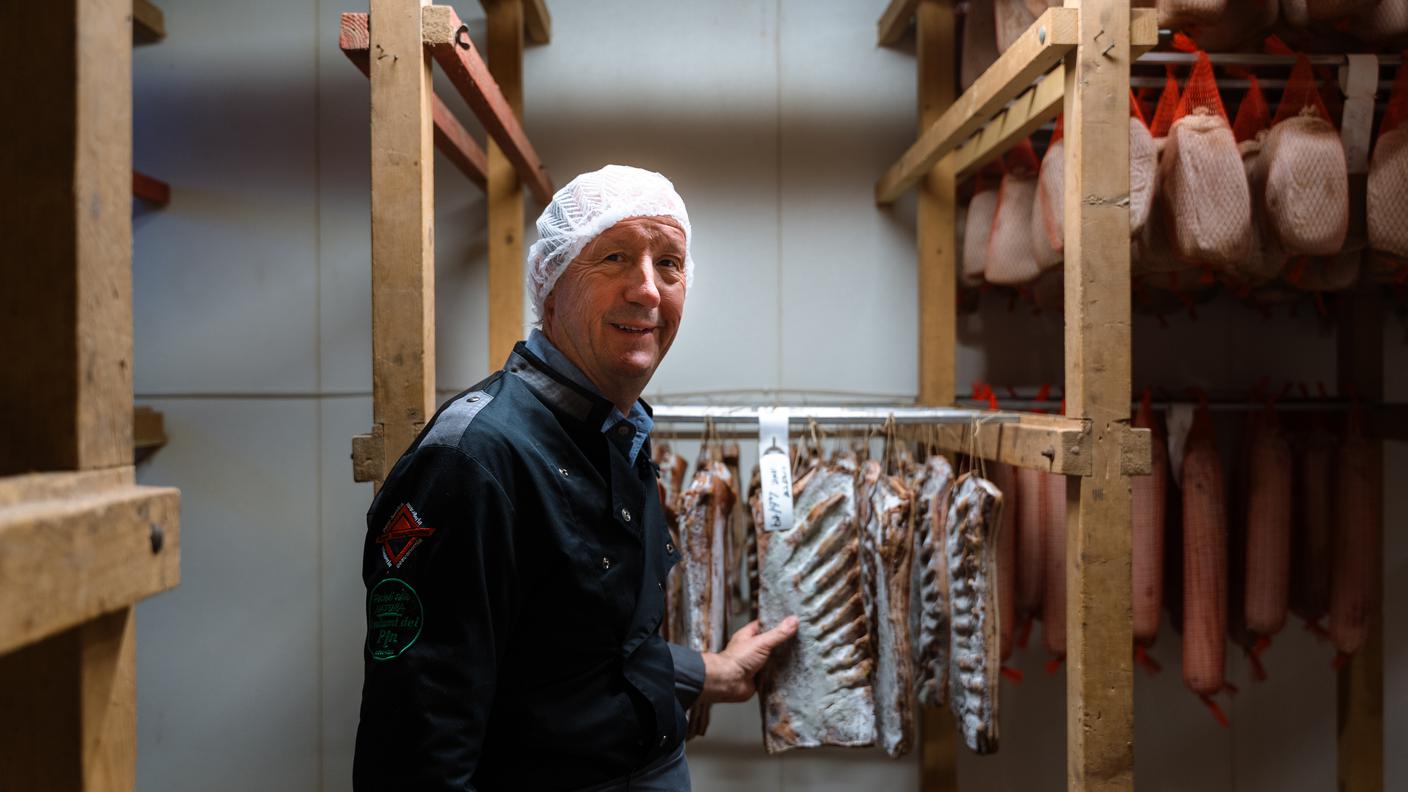Angelo Valsangiacomo è nato e cresciuto a Mendrisio, in una famiglia di agricoltori che allevava anche maiali, quando la mazza si faceva ancora in casa. Da ragazzo, dopo aver assistito a una mazza in casa, aveva giurato che non avrebbe mai fatto il macellaio. «Vedere la testa del maiale bollire mi era rimasto impresso. Avevo detto: mai più». E infatti voleva fare il carrozziere, ma il padre lo indirizza verso il mestiere della carne, aprendogli le porte di una storica famiglia di salumieri della regione. Dopo aver lavorato tra allevamento e macelleria, nel 1982 l’azienda di famiglia sposta i maiali in campagna; l’attività agricola prosegue fino al 1999. Valsangiacomo continua invece nel mondo della trasformazione, rilevando una macelleria e poi tornando in via Stella, a Mendrisio, dove raccoglie l’eredità di un salumificio attivo dal 1922. Ancora oggi lavora nel segno della continuità, convinto che conoscere l’origine della carne e chi la trasforma sia un valore irrinunciabile.