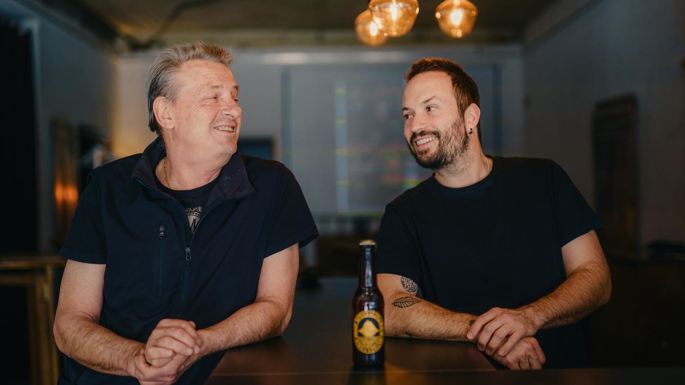 Eric e Lucio Notari. Per Eric la birra comincia molto prima del birrificio: nei primi assaggi rubati da ragazzo dal frigorifero del nonno, nei viaggi in moto attraverso l’Europa per scoprire le birre dei pub locali, nei manuali studiati per capire che cosa renda una birra davvero buona e nei tentativi fatti in casa con malto, luppolo e lieviti. Lucio, allora bambino, ricorda soprattutto i grandi bidoni blu piazzati in salotto e quell’odore insolito che invadeva la casa. Da quelle prove domestiche prende forma, nel 1999 a Bioggio, l’Officina della Birra: primo brew-pub del Ticino e una delle realtà che segnano il ritorno della produzione birraria nel Cantone. Anni dopo, entrando a sua volta nell’attività, Lucio avrebbe dato continuità a una storia familiare intrecciata con il nuovo corso della birra ticinese.