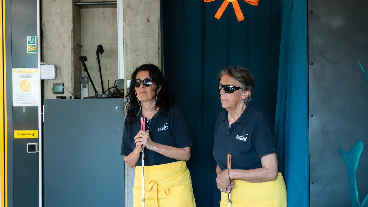 Barbara Veccia e Marisa Varano: sono due delle nove persone che lavorano come cameriere nel progetto Moscacieca. Entrambe descrivono il proprio lavoro con passione, sottolineando come richieda grande concentrazione. Raccontano di trovare sempre nuovo entusiasmo, alimentato anche dalla soddisfazione e dalla curiosità dei clienti.