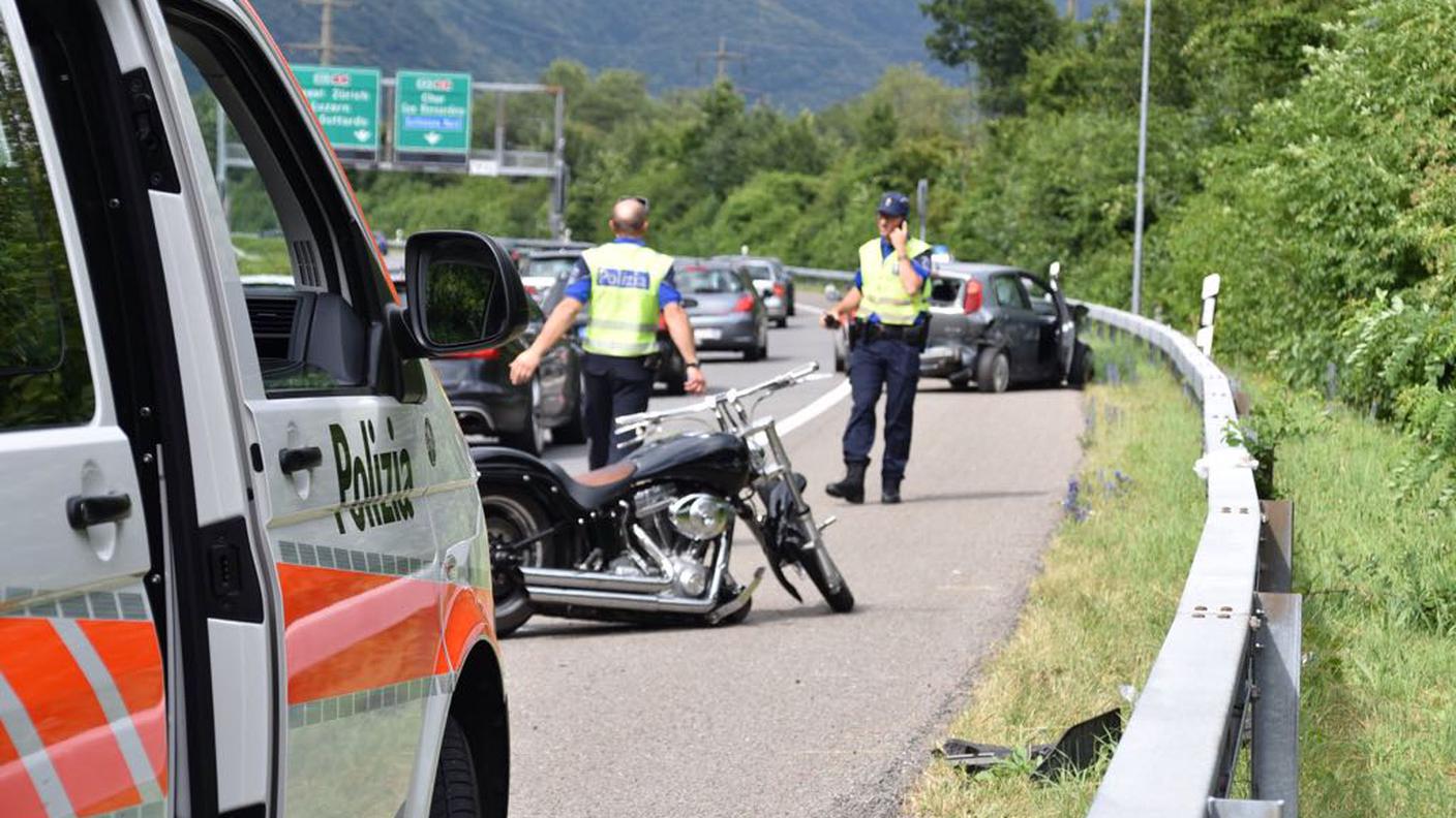 In primo piano la moto, sullo sfondo l'auto 