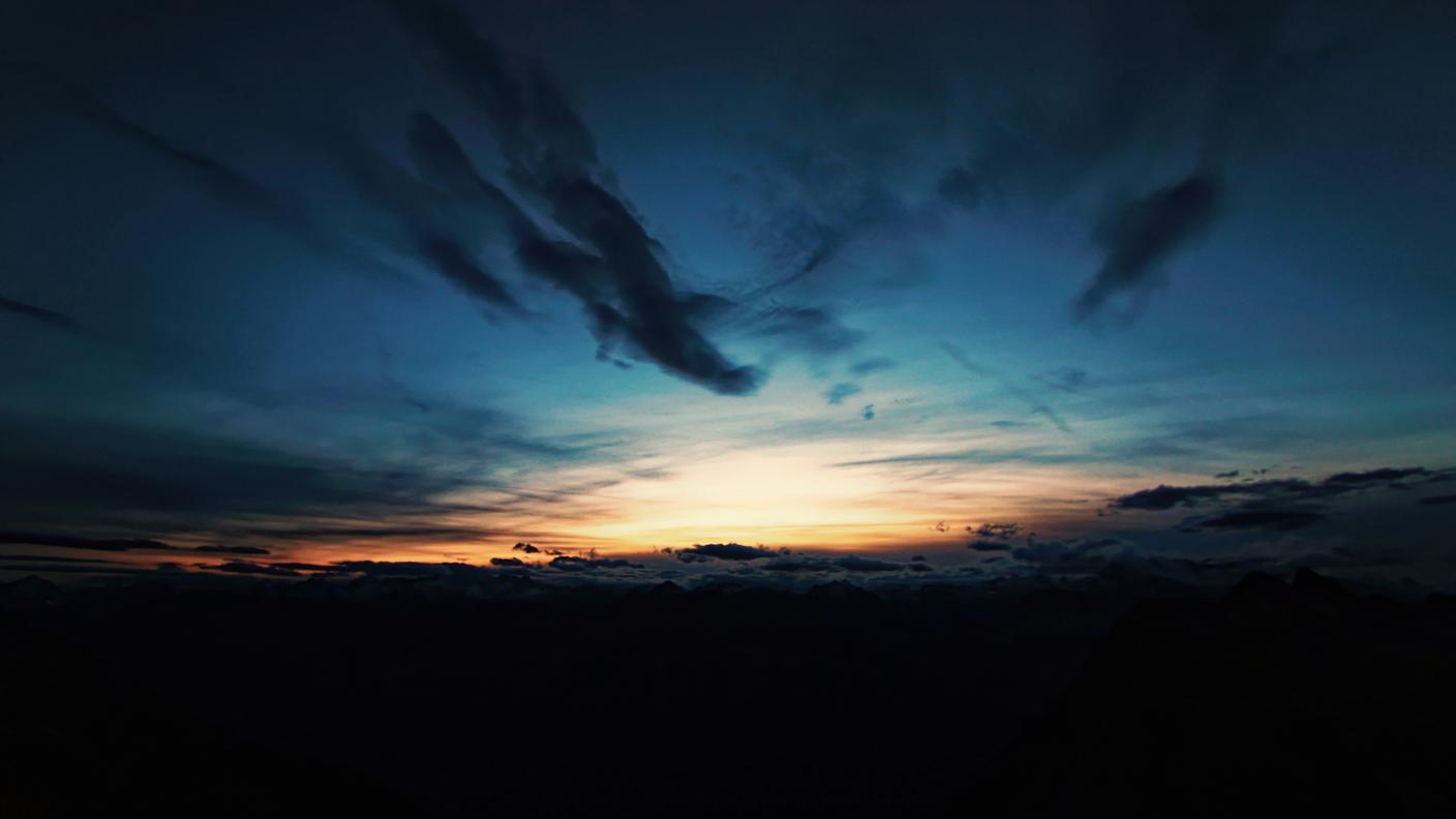 L'ultimo sole, dalla terrazza della capanna, si spegne mentre a valle è già notte