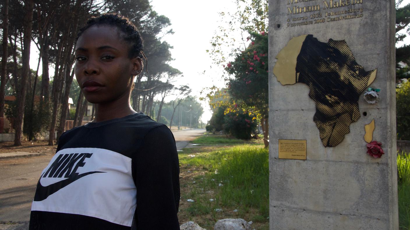 Lola Bello, 27 anni, nata in Italia. Studentessa universitaria, ha ricevuto la cittadinanza nel 2015, dopo tre anni dalla richiesta ufficiale. Dietro di lei il memoriale dedicato a Miriam Makeba, cantante e attivista politica sudafricana scomparsa nel 2008 a Castel Volturno dove si trovava per un concerto.