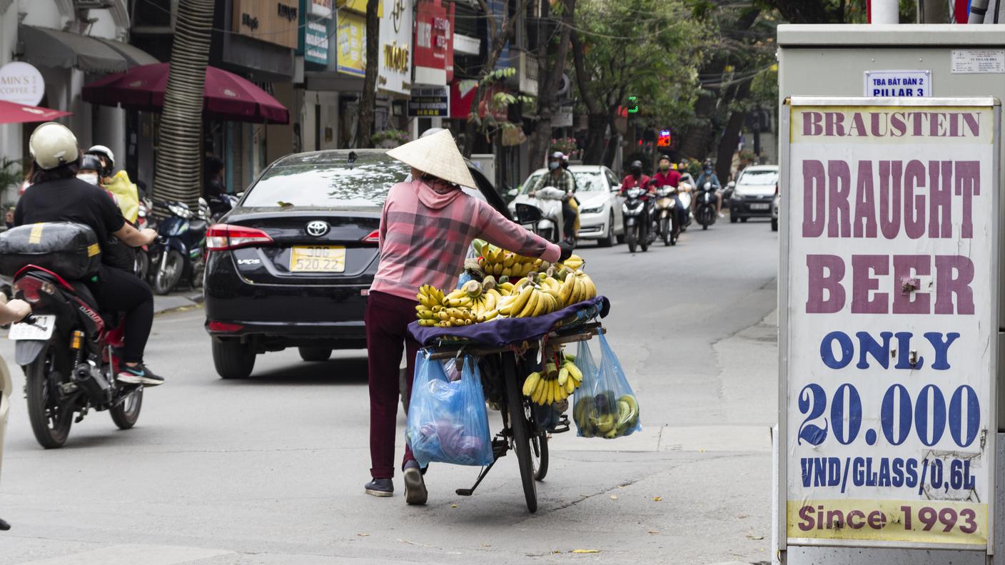 Un tradizionale venditore ambulante nelle strade di Hanoi. Le stringenti politiche di contenimento dei contagi hanno portato a un forte calo delle vendite