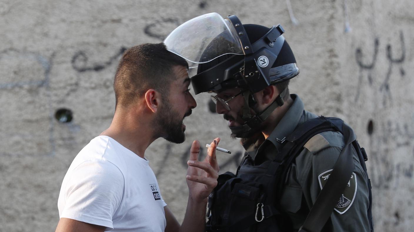 Poliziotto israeliano arresta un manifestante palestinese durante una protesta nel quartiere di Sheikh Jarrah a Gerusalemme est, il 15 maggio