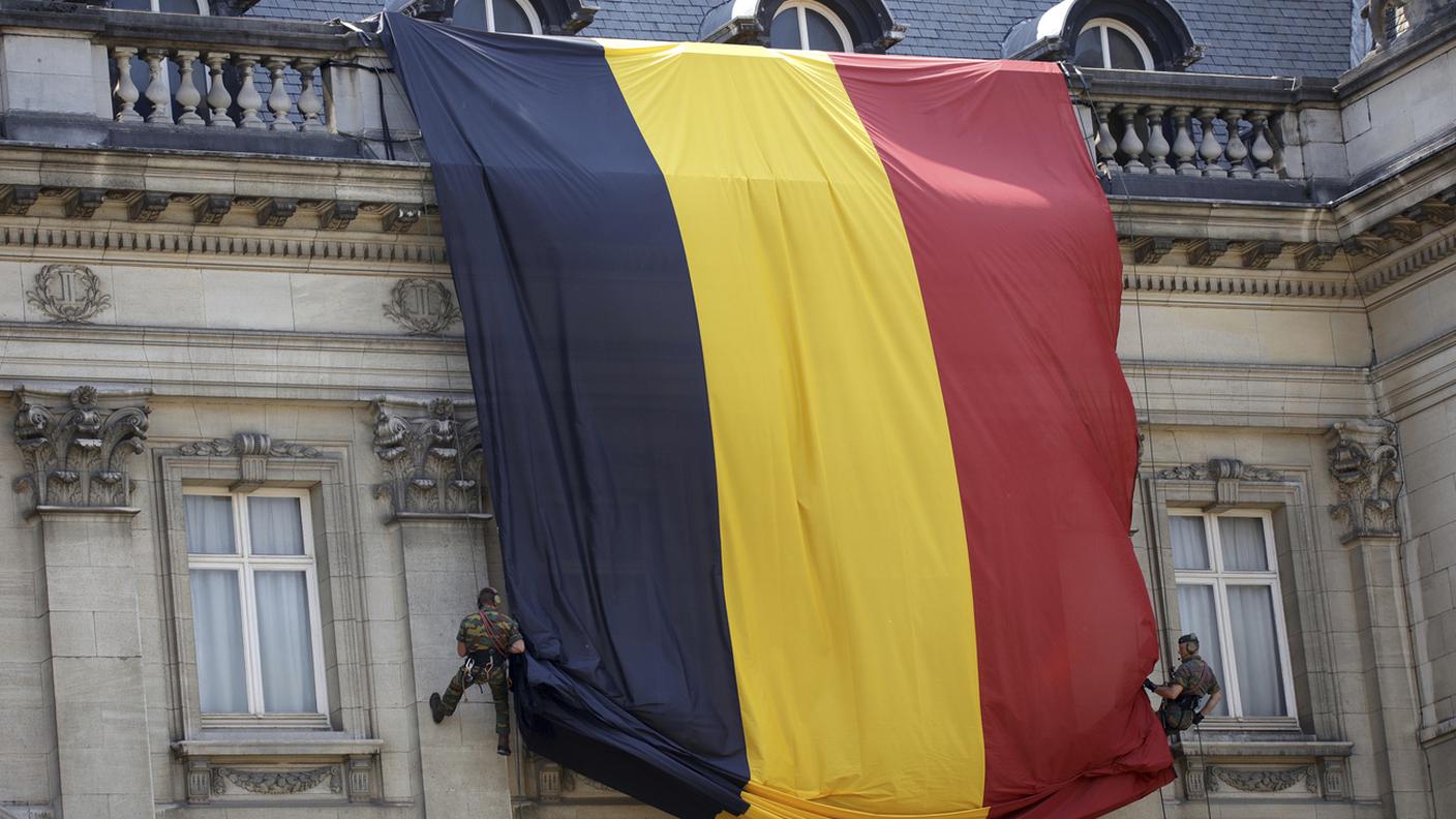 I para srotolano la bandiera belga sulla facciata del Palazzo Reale a Bruxelles per l'annuale parata del 21 luglio