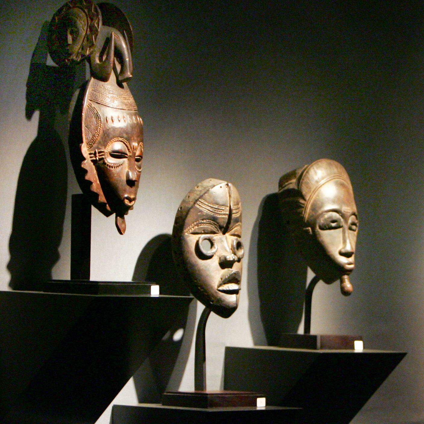 Un visitatore dà un'occhiata ad alcune delle maschere africane che fanno parte di una collezione appartenente ad alcuni collezionisti Francesi, Parigi.