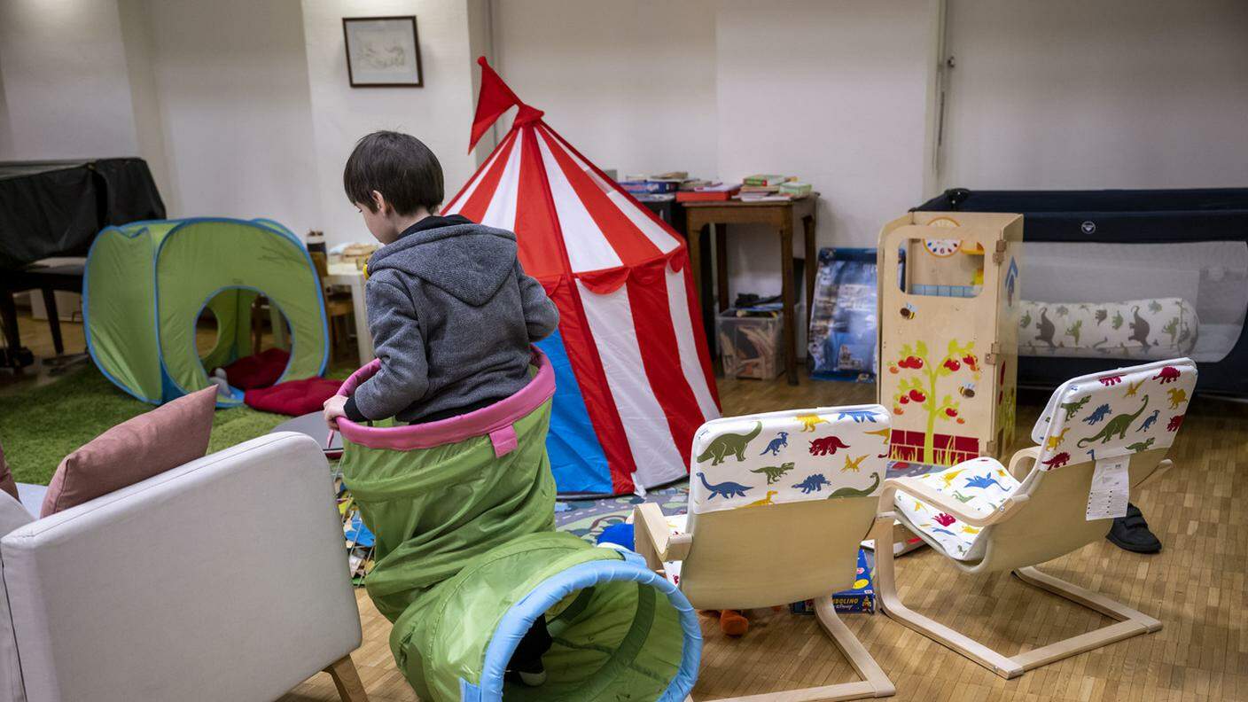 Un bimbo ucraino gioca nella sua nuova casa a Ginevra