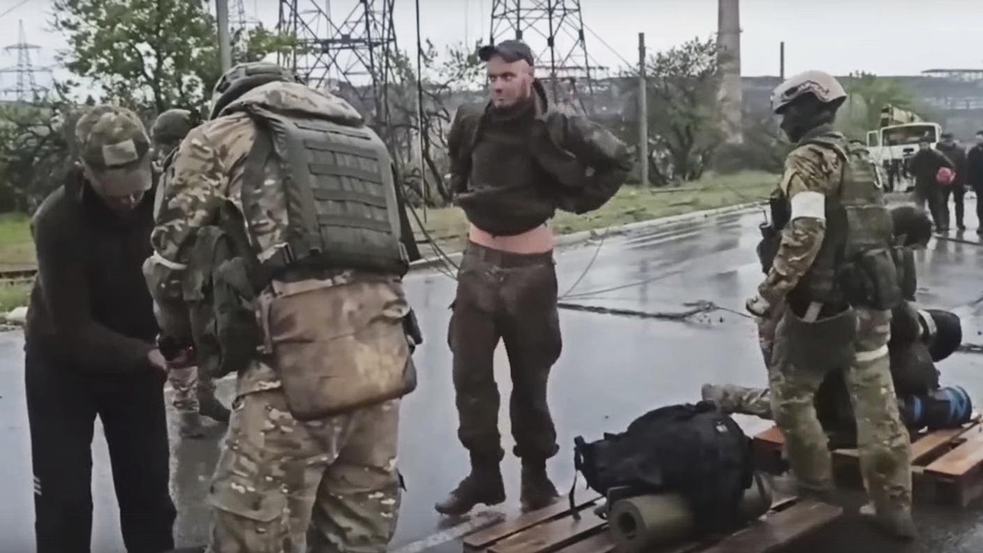 Soldati russi perquisiscono i combattenti del battaglione Azov che si sono arresi
