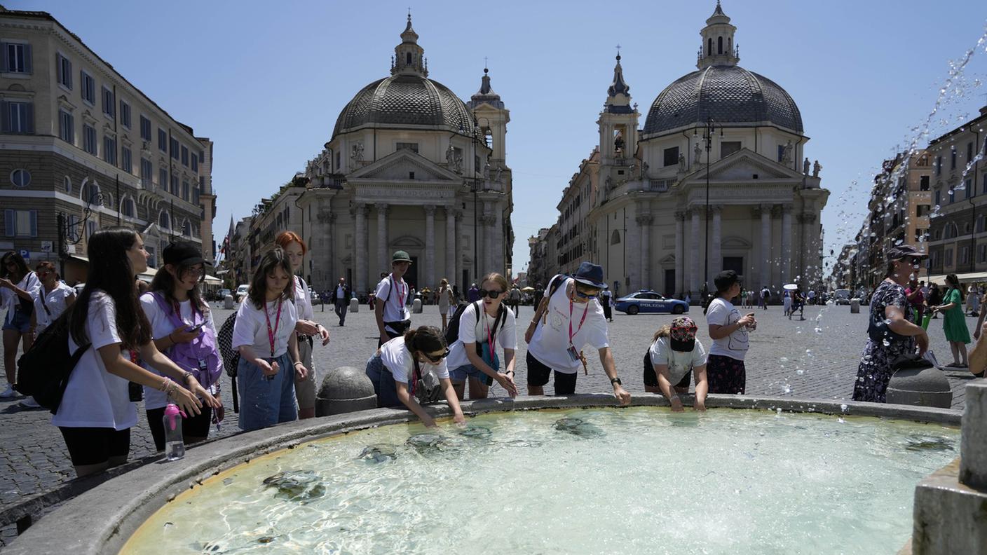 Turisti si rinfrescano in una fontana di Piazza del Popolo a Roma