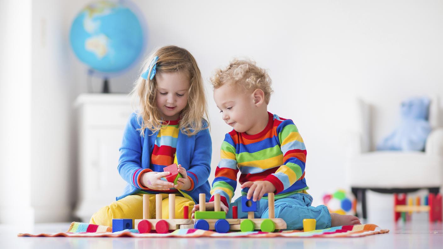 Bambini che giocano con giocattoli in legno treno