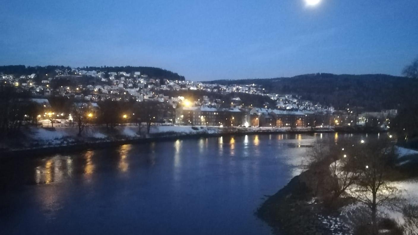 Una foto della città con la neve e la luna alle 13:00