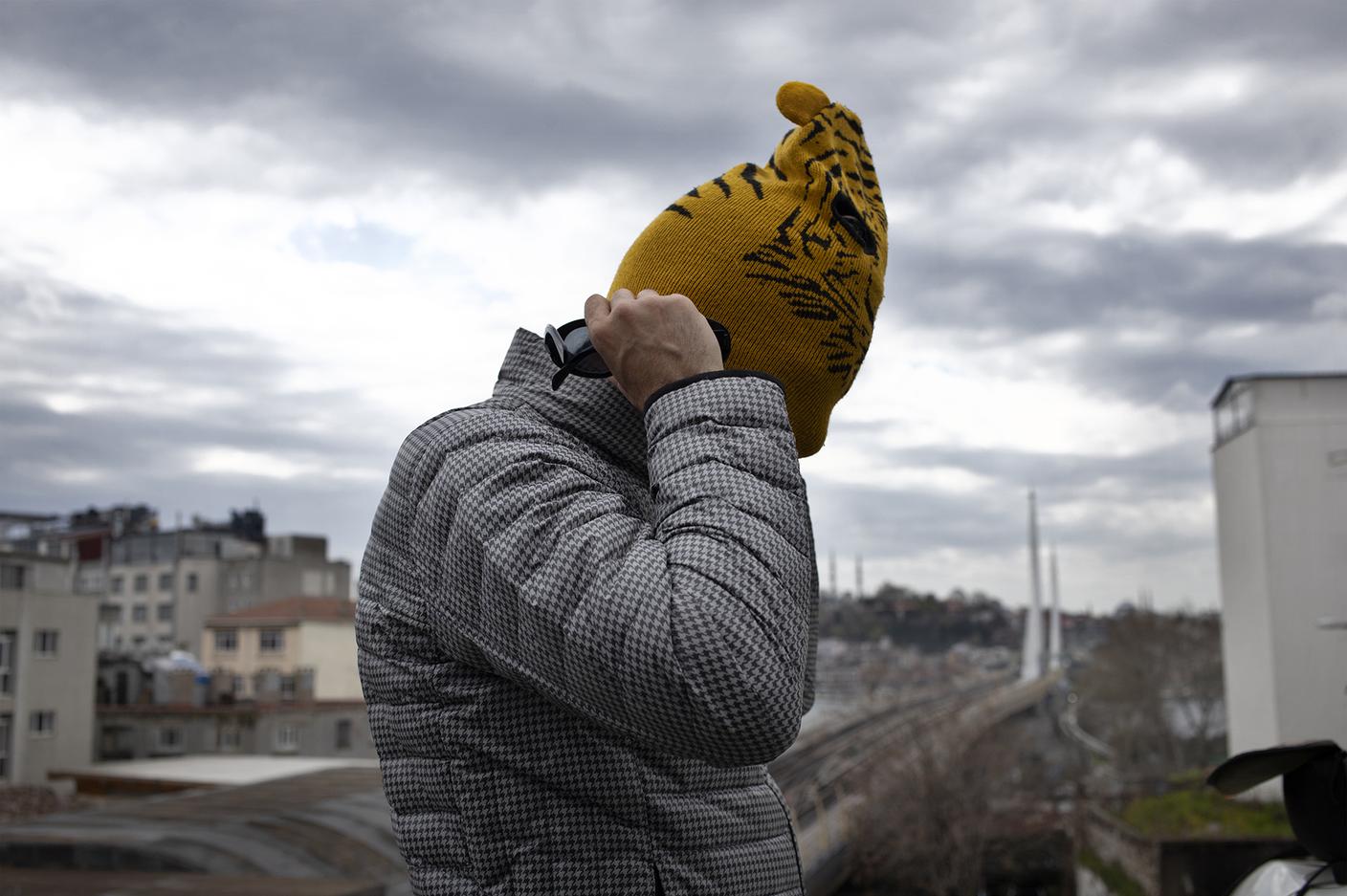 Sulla collina dove la metropolitana di Istanbul attraversa il Corno d'Oro, l'artista indossa la maschera per coprire la propria identità.