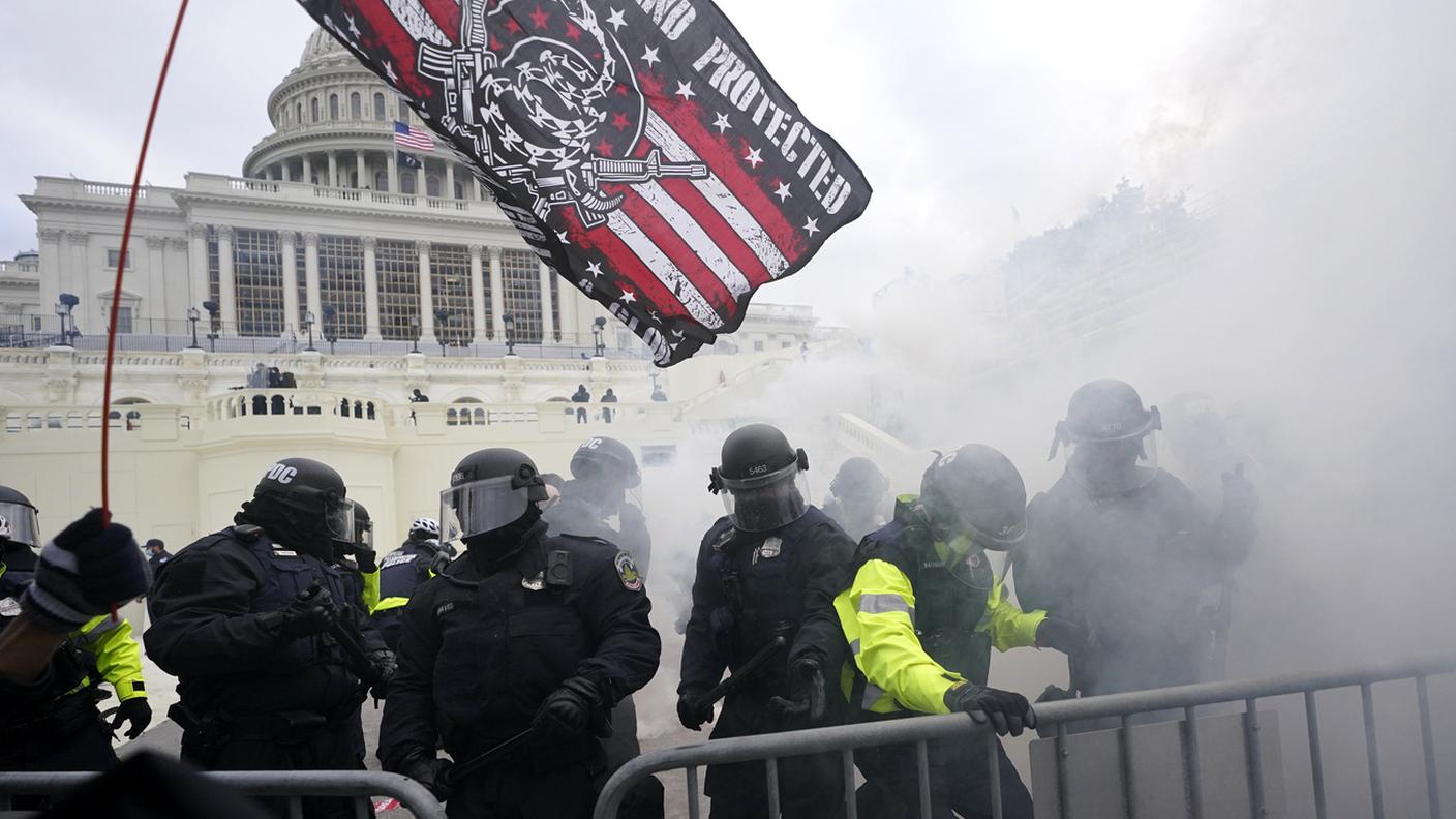 La polizia respinge i sostenitori di Trump che hanno tentato di sfondare una barriera, mercoledì 6 gennaio 2021, al Campidoglio di Washington. Mentre il Congresso si prepara a confermare la vittoria del presidente eletto Joe Biden, migliaia di persone si sono radunate per mostrare il loro sostegno al presidente Donald Trump e alle sue accuse di frode elettorale.