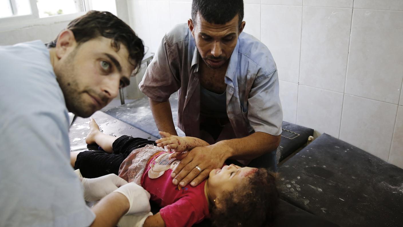 Un padre conforta la figlia ferita dagli attacchi israeliani