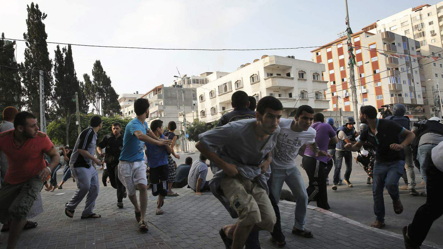 Cittadini palestinesi fuggono dai colpi dell'esercito israeliano 