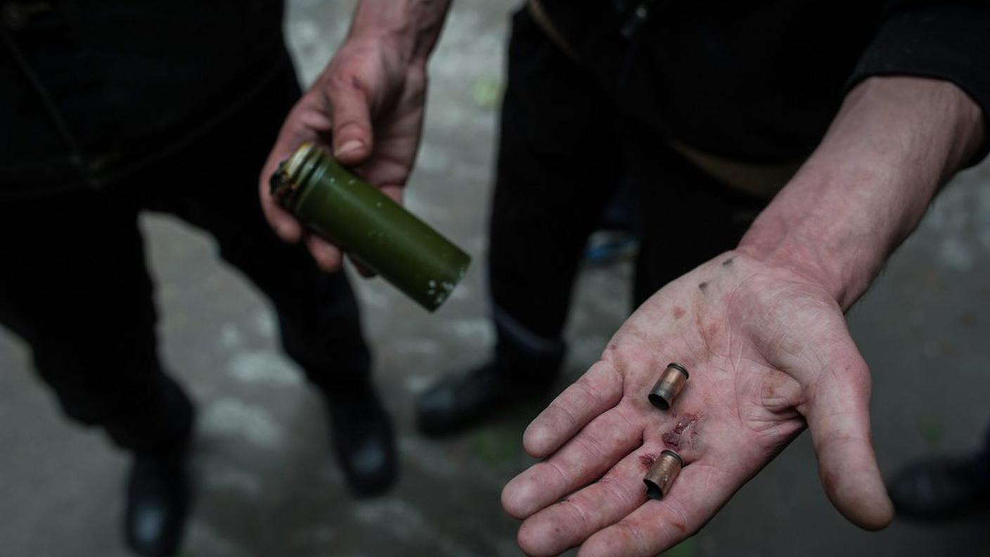 Un manifestante pro-russo mostra i bossoli delle pallottole usate dall'esercito ucraino vicino alla stazione di polizia di Mariupol