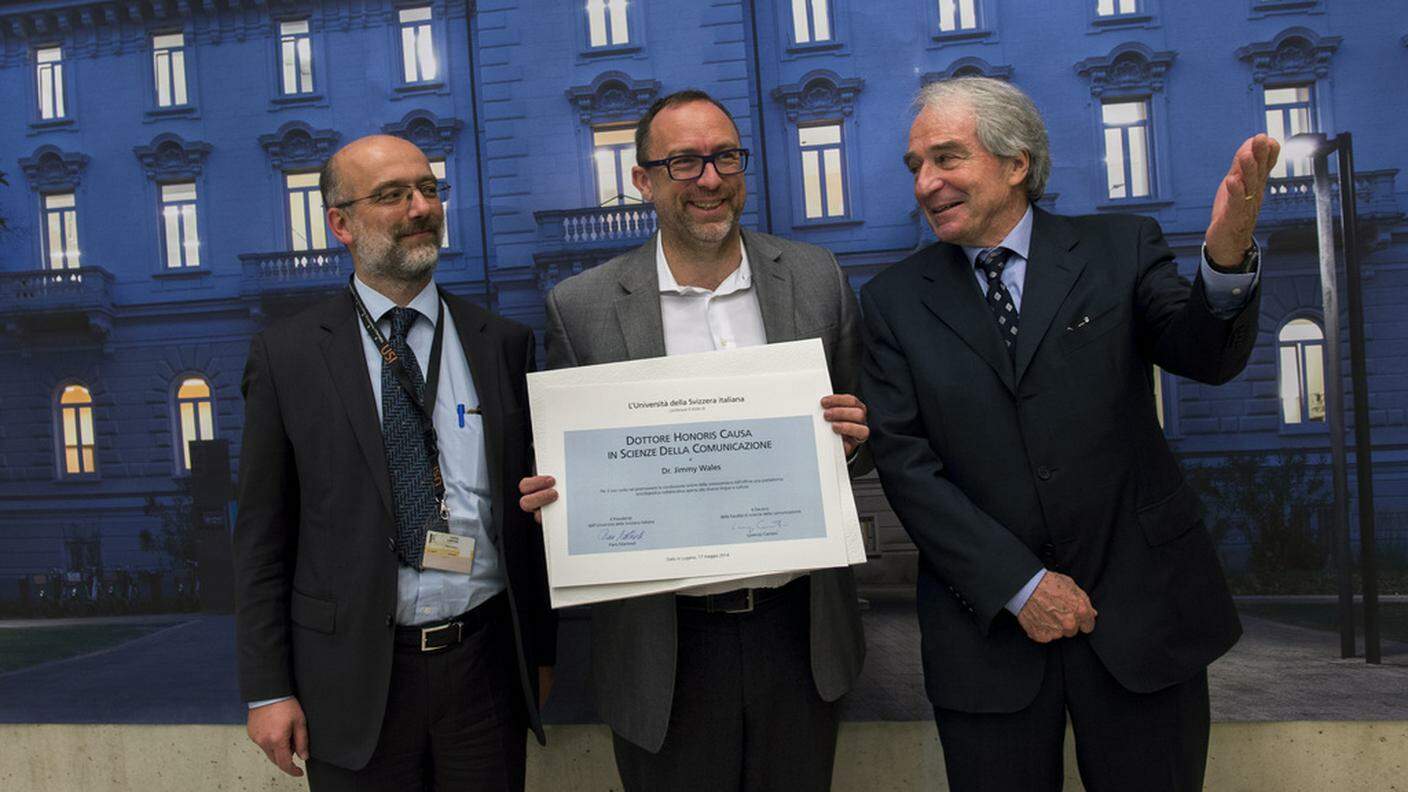 Wales con il dottorato honoris causa, fra il decano della facoltà di scienze della comunicazione, Lorenzo Cantoni, e il presidente dell'USI, Piero Martinoli
