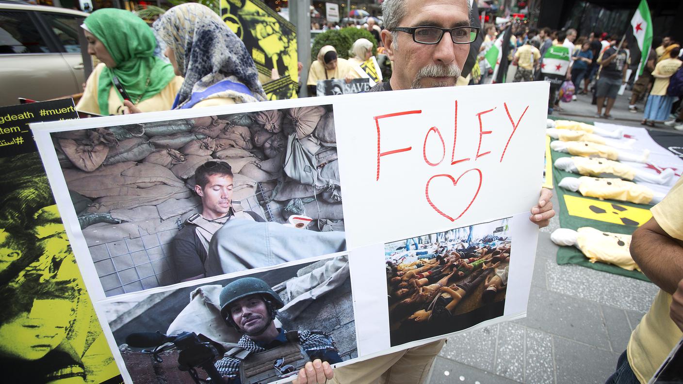 Un uomo ricorda James Foley durante una manifestazione a New York