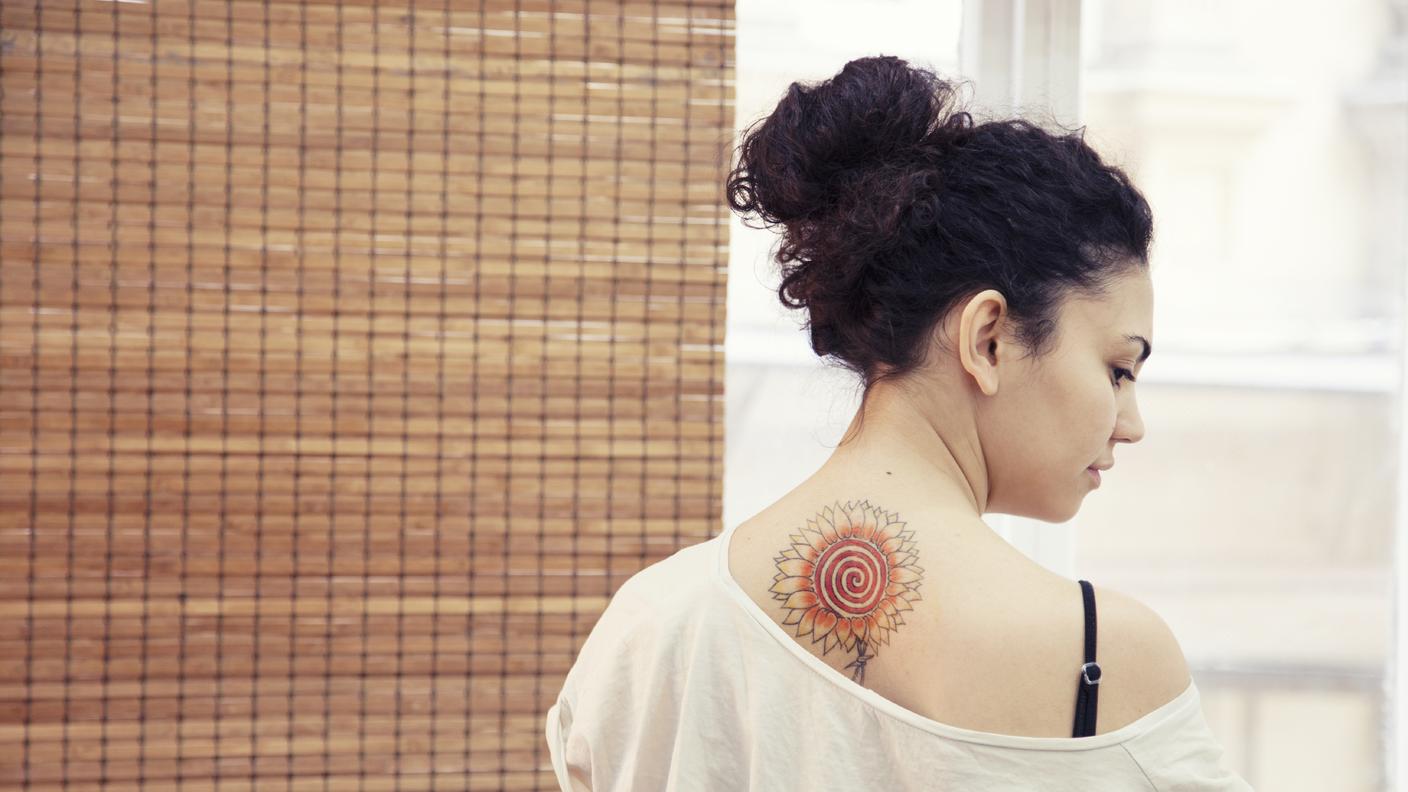 iStock_tatuaggio_ragazza_schiena_girasole_fiore_spalla.jpg