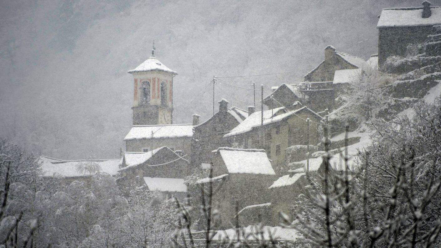 Un paese di valle sotto una leggera coltre di neve
