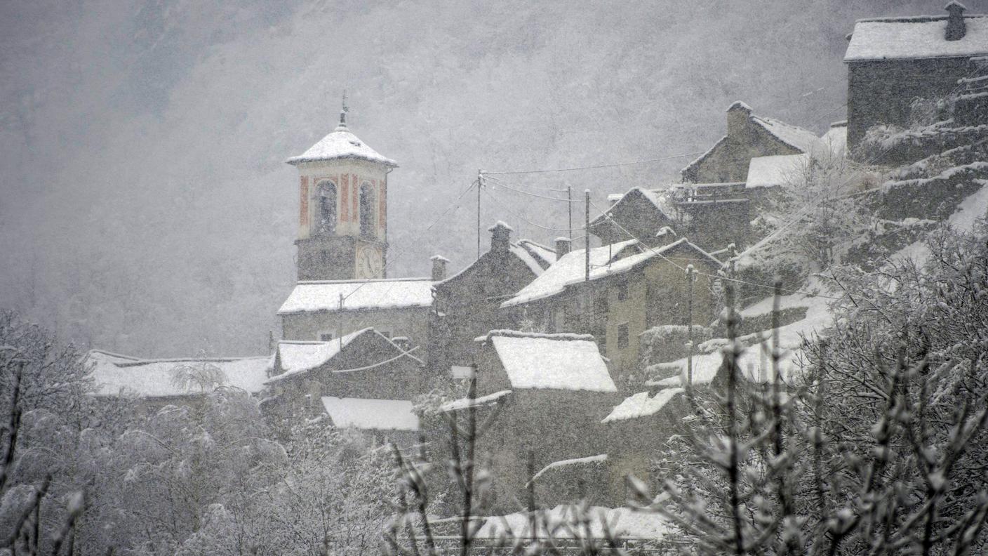 Un paese di valle sotto una leggera coltre di neve