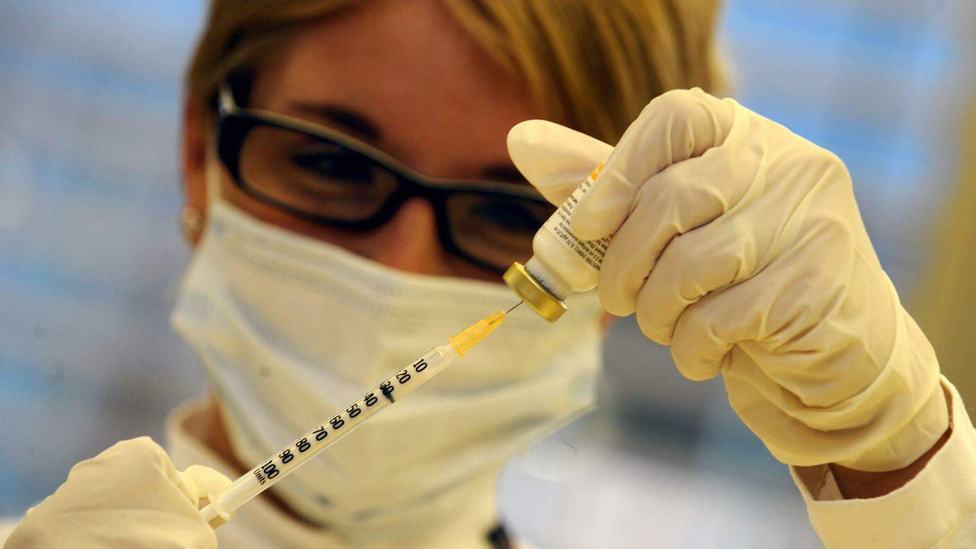 Un'infermiera prepara il vaccino aspirandolo in una siringa
