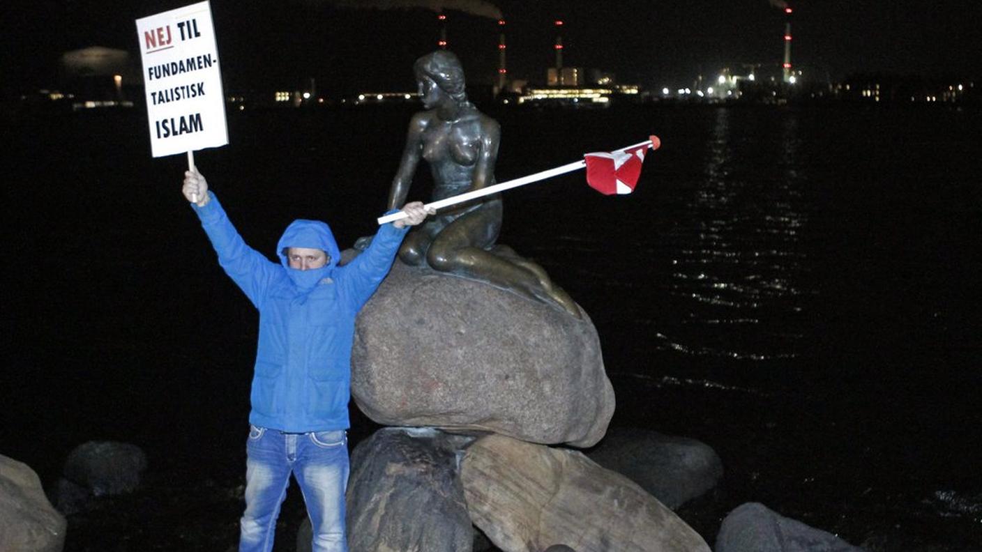Un manifestante di Pegida davanti alla sirenetta di Copenhagen