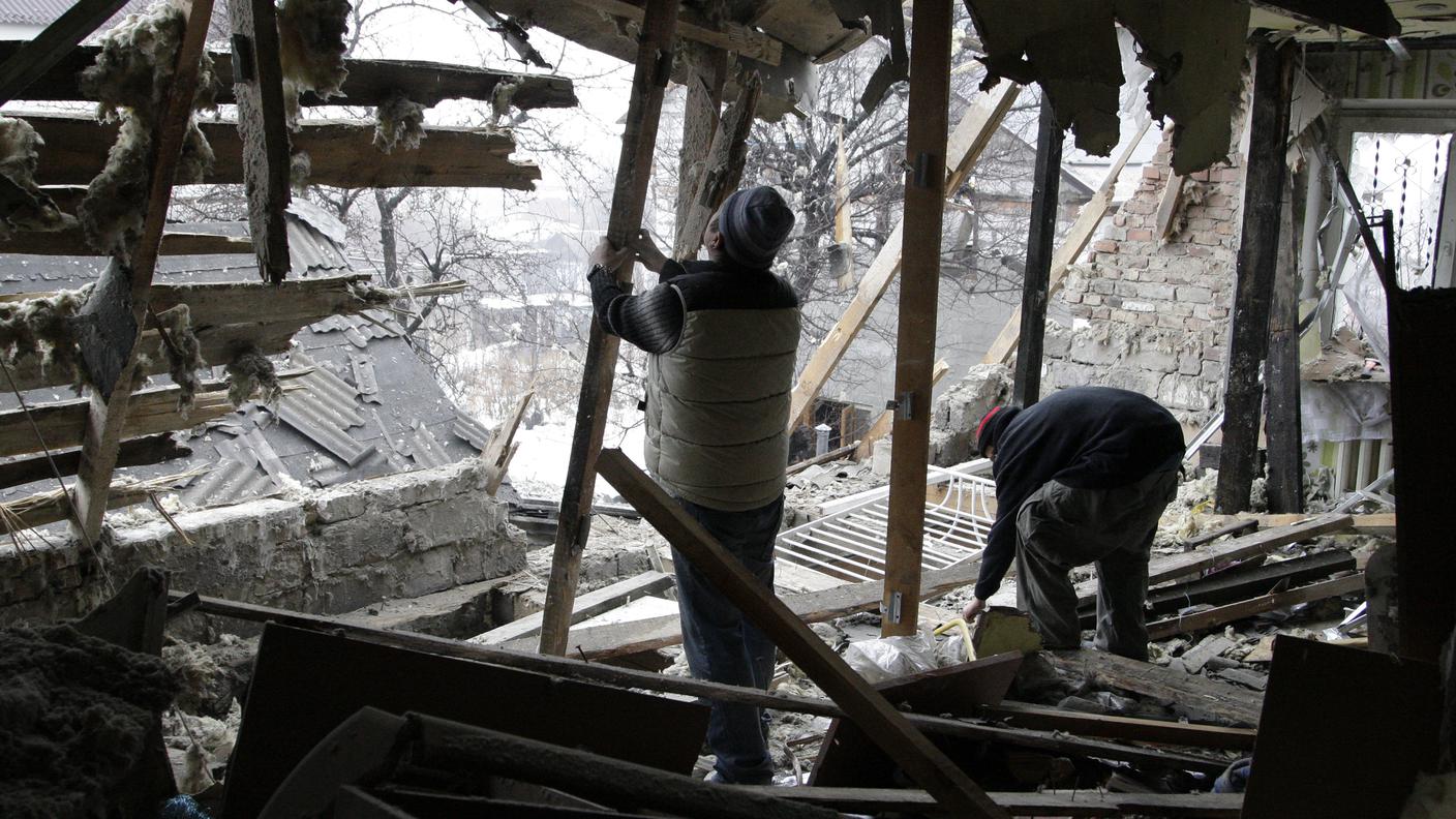 Alcuni abitanti di Donetsk sistemano quel che resta di una casa distrutta Reuters.jpg