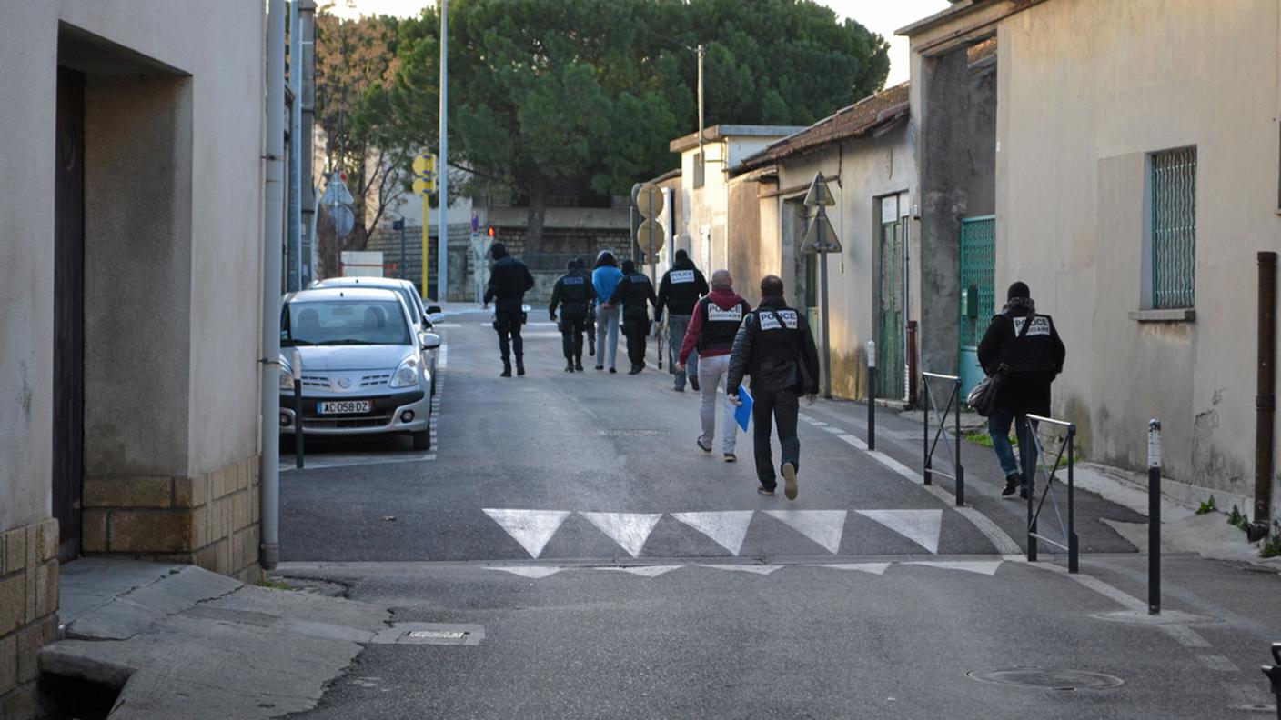 Uno degli arrestati di Lunel portato via dalla polizia