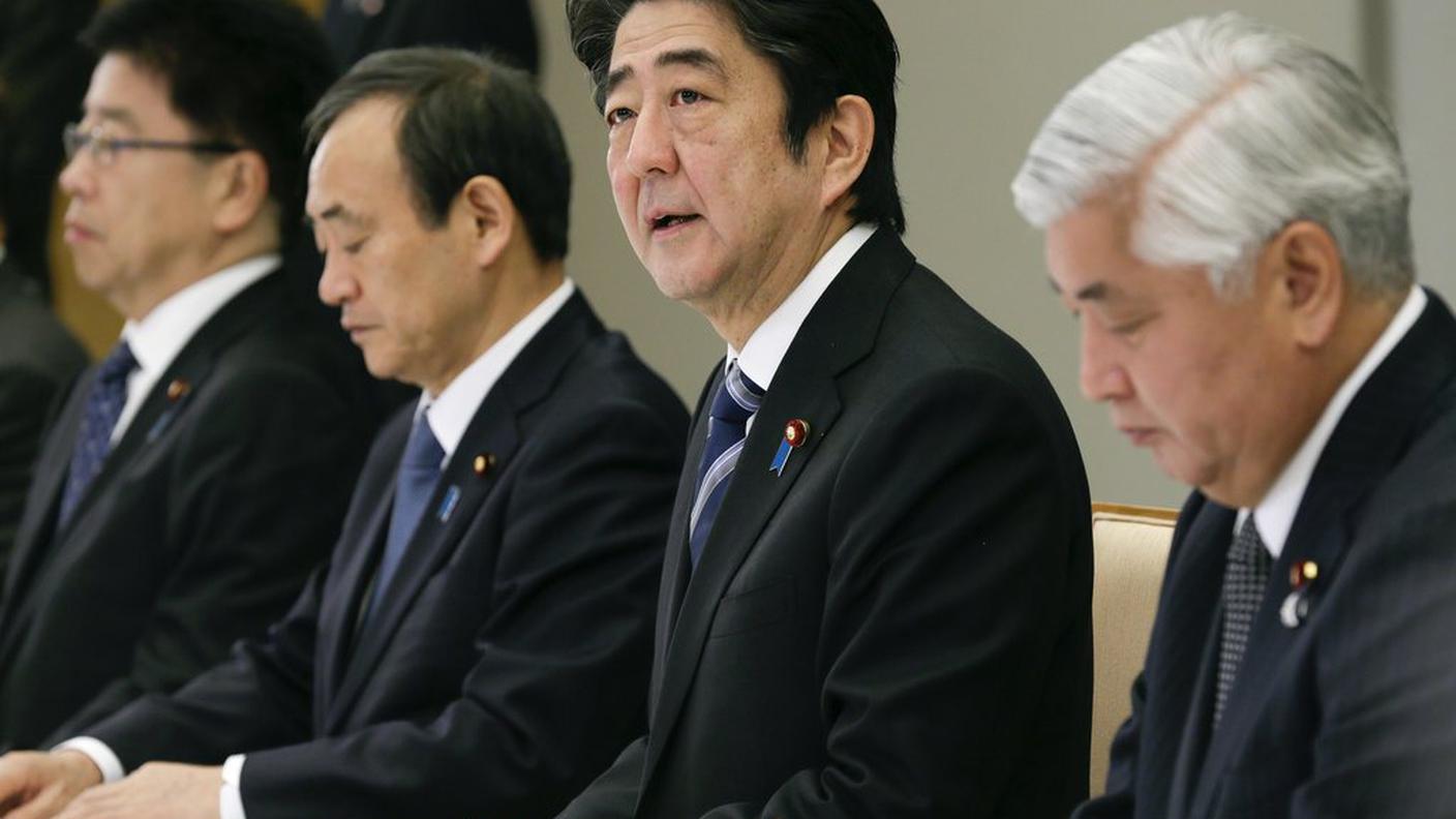 Shinzo Abe (al centro) in un'immagine scattata domenica a Tokyo