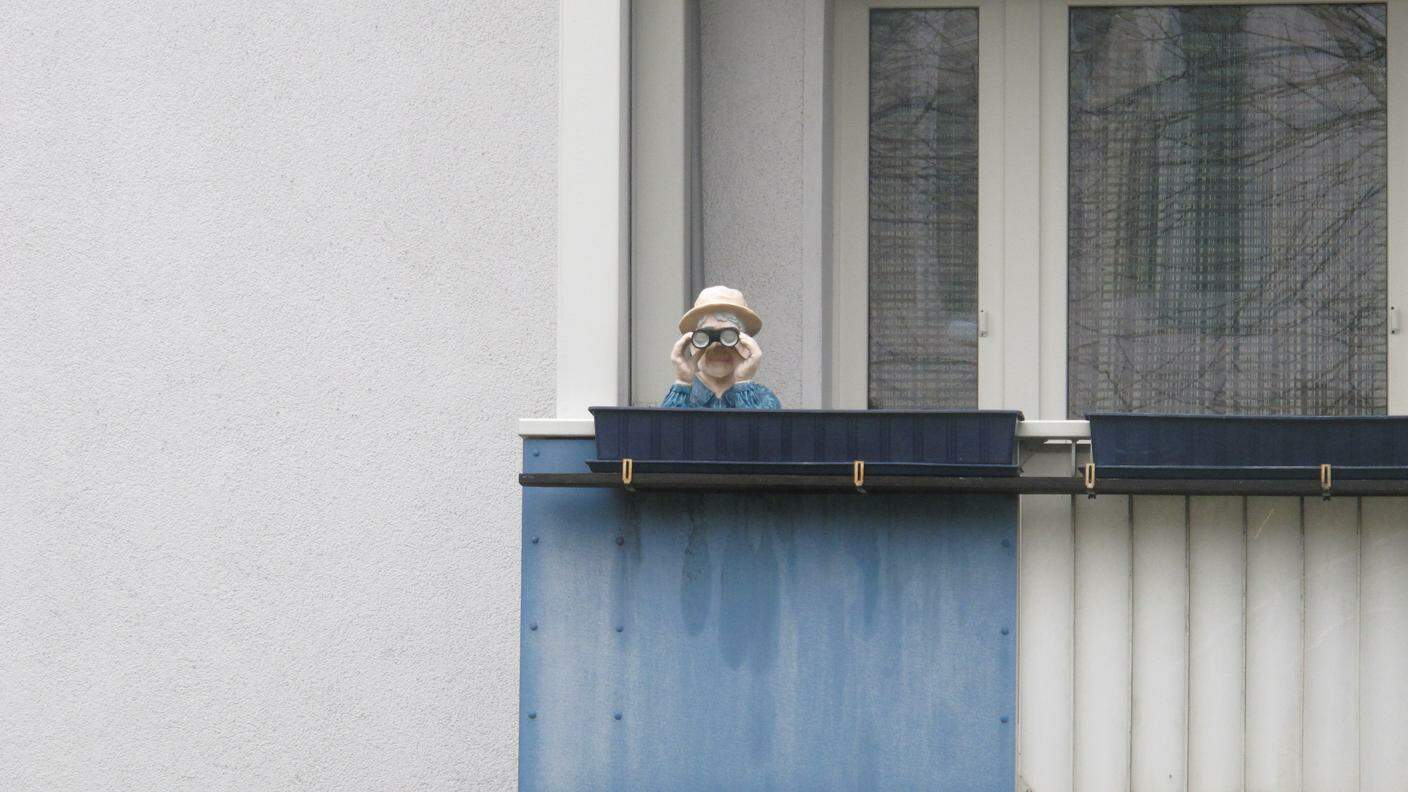 Scultura ironica, sul balcone di un condominio, in faccia alla sede della BND