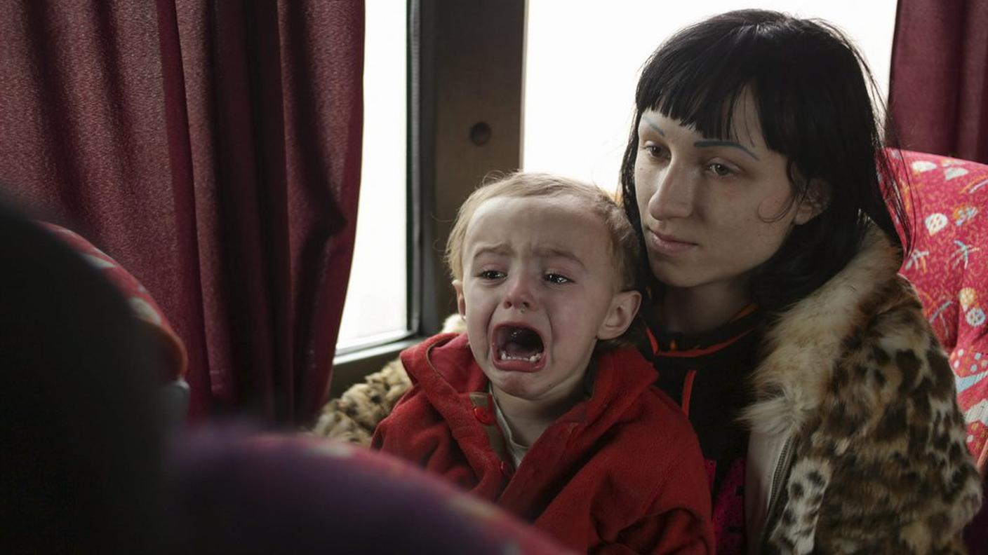 Una donna e il suo bambino in fuga dalla zona dei bombardamenti
