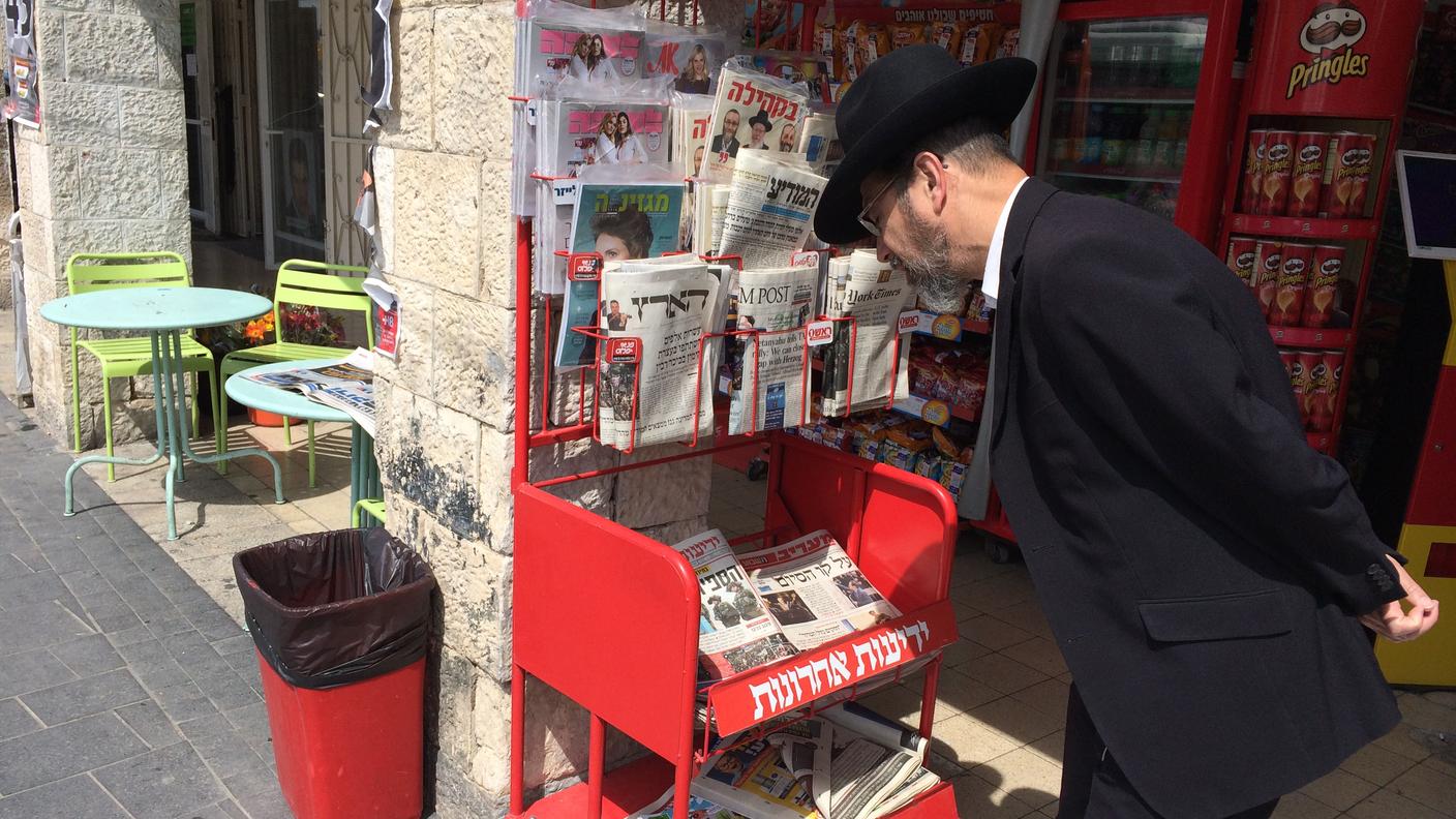 Un religioso ortodosso legge i titoli giornali