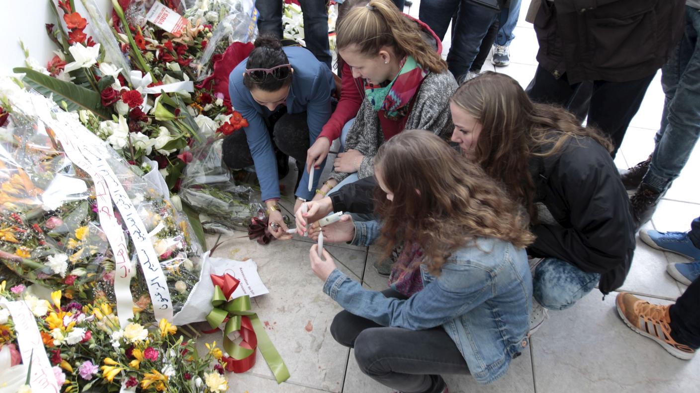 Un gruppo di turiste accende candele davanti al Museo del Bardo