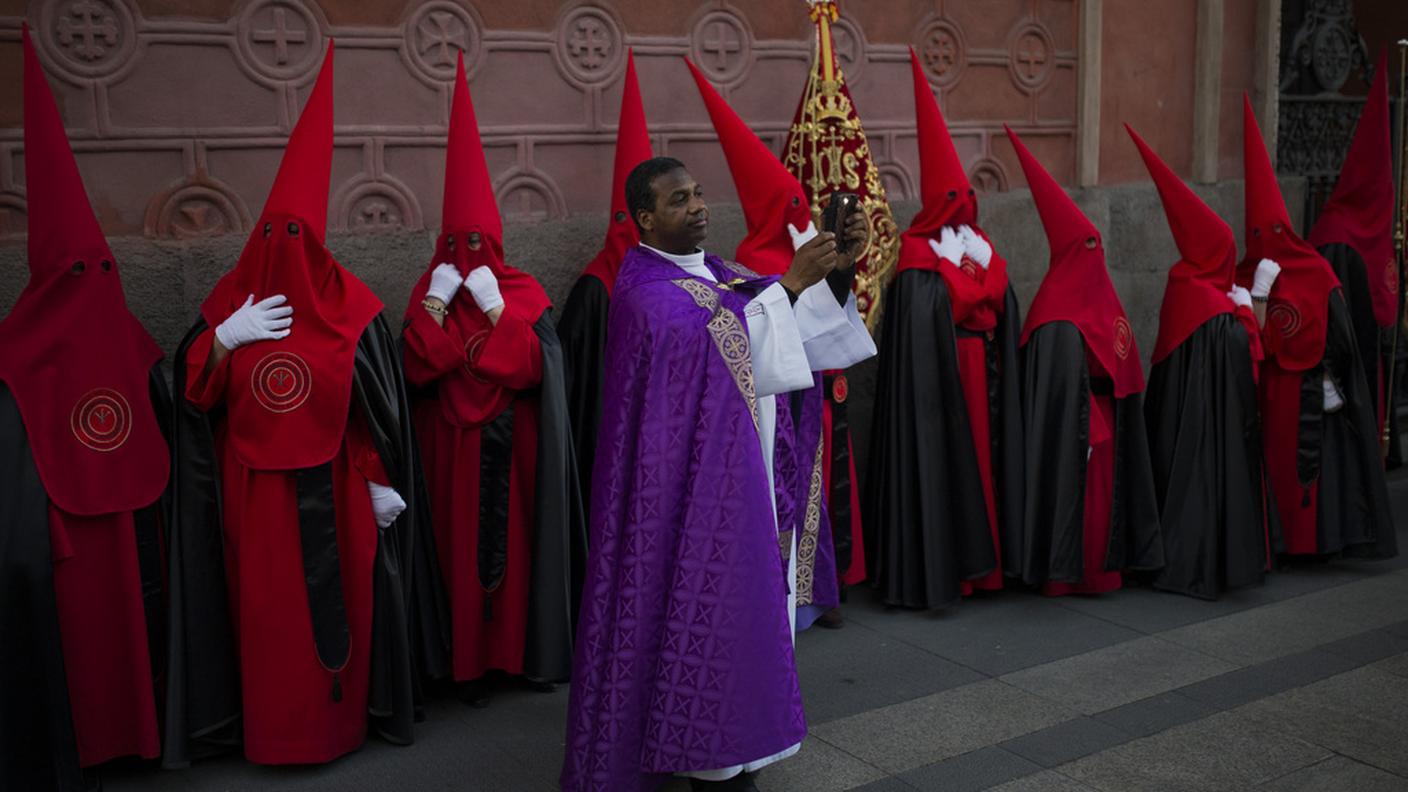 Penitenti con tradizionali tuniche e cappucci rossi e neri, a Madrid in Spagna