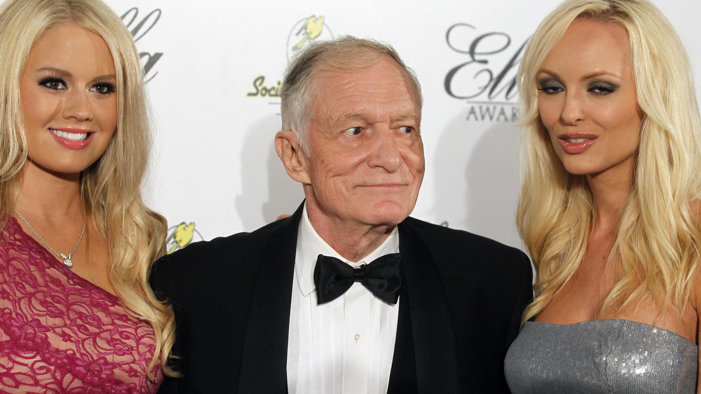 Hugh Hefner ritratto tra due playmates in una foto del 2011