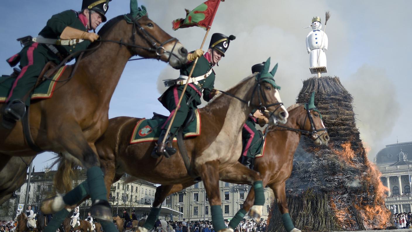Cavalieri con costumi tradizionali, intorno alla pira accesa