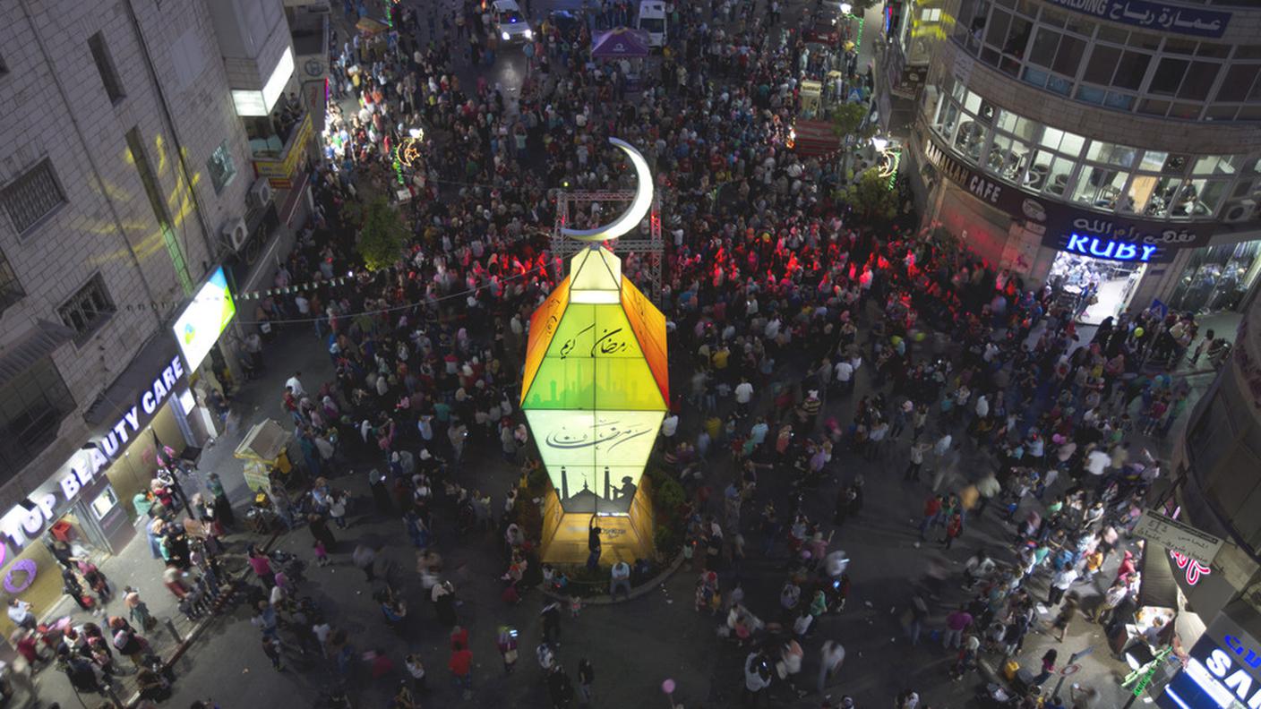 A Ramallah i fedeli palestinesi guardano la lanterna che segna l'inzio del Ramadan