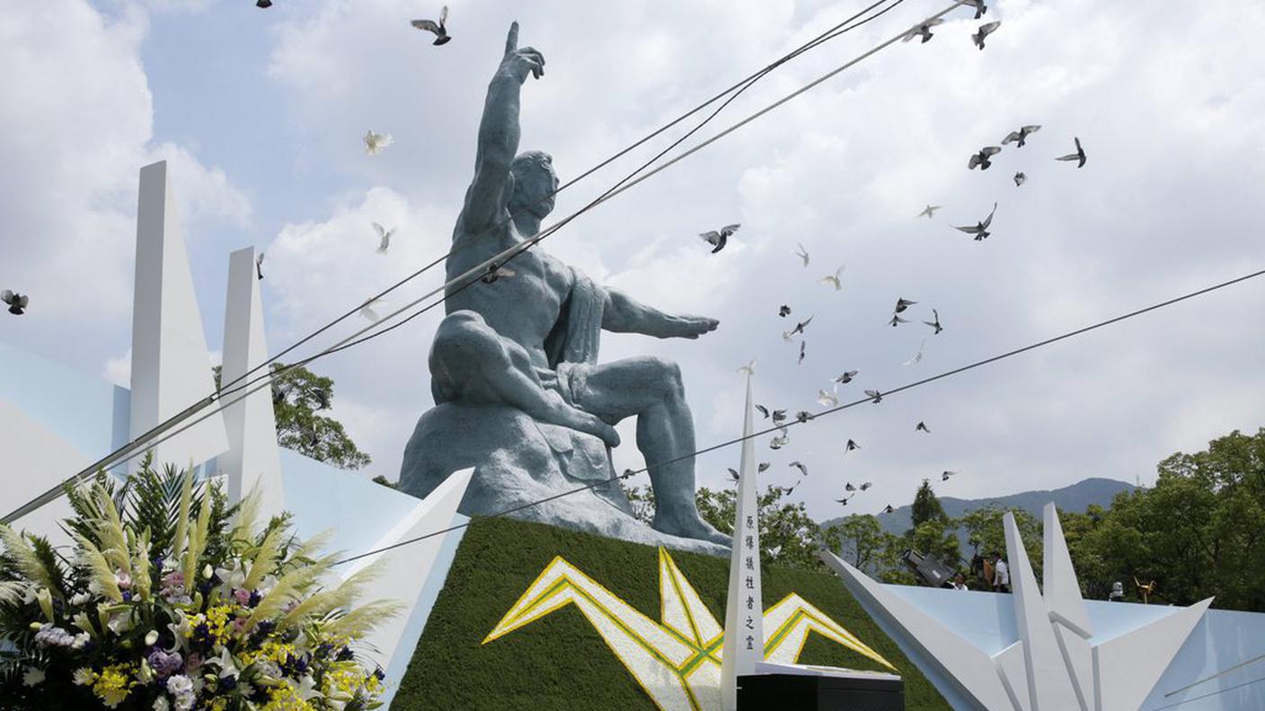 Colombe in volo sopra la statua nel parco memoriale della pace