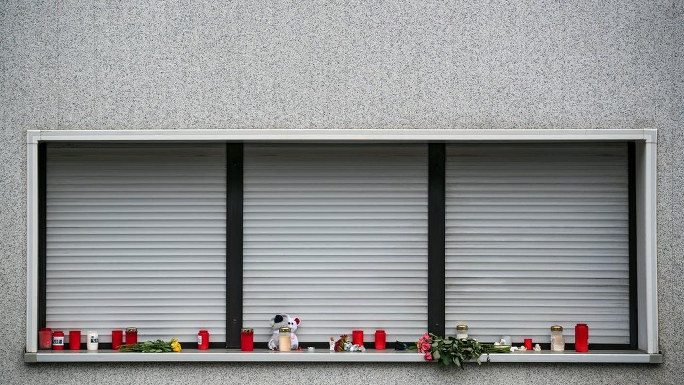 Fiori e candele davanti all'abitazione dove sono stati trovati gli 8 corpi