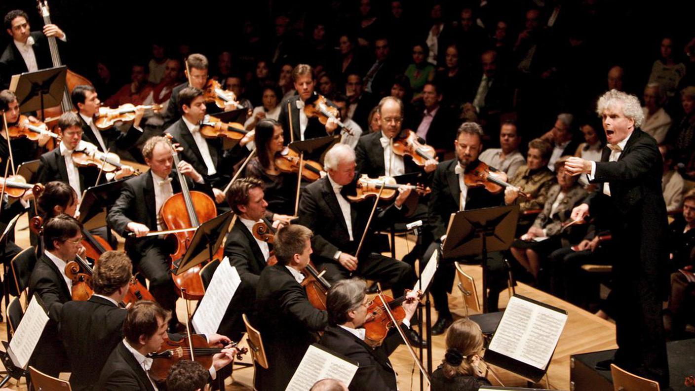 Il maestro Simon Rattle mentre dirige la Berliner Philharmoniker 