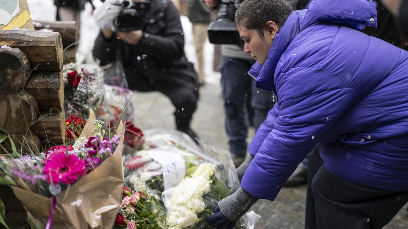 Roze, rimasta ferita nell’incendio, depone fiori davanti al bar “Le Constellation” a Crans-Montana per commemorare le altre vittime